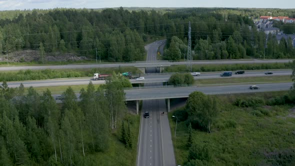 Still aerial view of a motorway overpass as two people walk under the bridge.