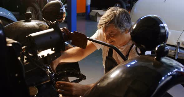 Male mechanic servicing a car 