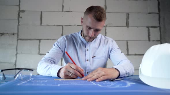 Construction engineer working in the office with blueprints