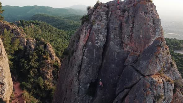 Climbing mountain in Spain. Drone aerial view of climber woman and man that climb a big rock.