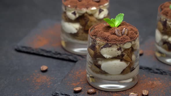 Classic Tiramisu Dessert in a Glass on Stone Serving Board on Dark Concrete Background
