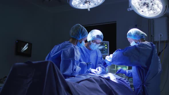 Diverse surgeons wearing surgical caps and face masks in operating theatre in hospital