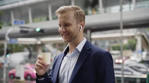 Businessman having phone call with earbuds, Bangkok, Thailand