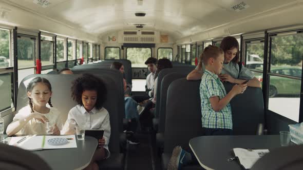 Teen Classmates Sitting Schoolbus Talking