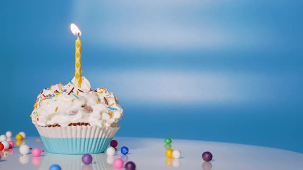 Birthday Cupcake With Candles And Decorations On A Blue Background. Copy Space alt