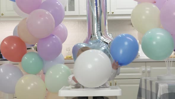 Happy Baby Boy Playing with Helium Balloons at His First Birthday Party Oneyearold Child Against the