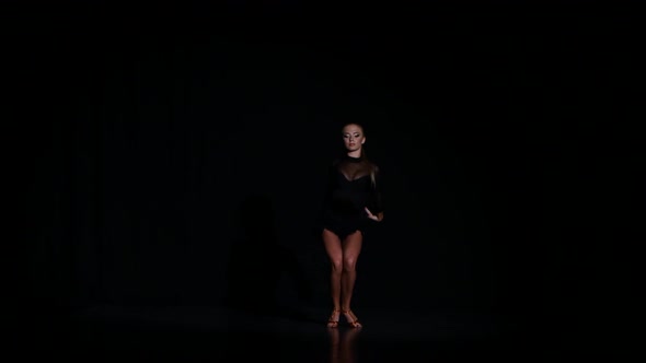 Professional Beautiful Dancer in a Studio on a Dark Background