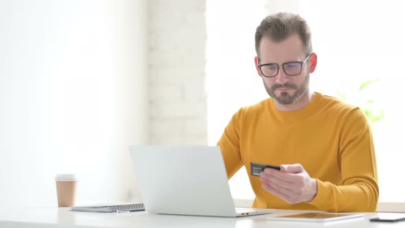 Man Making Online Payment Failure on Laptop in Office