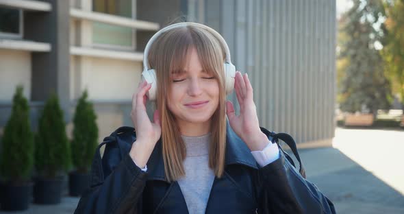 Happy Cool Blonde Woman Wearing Headphones Dancing Alone on Street