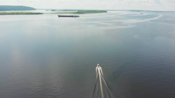 Motor Boat on River and Barge Passing By - Green Islands on the Water