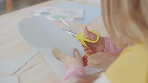 Unrecognizable Girl Cutting out Paper Heart