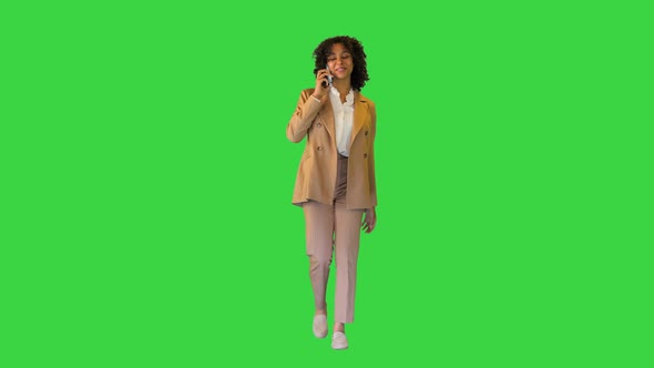 Happy African American Lady Walking and Talking on the Phone on a Green Screen Chroma Key