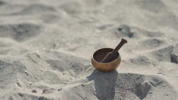 Bronze Tibetan Singing Bowl for Meditation on the Sandy Sea Beach