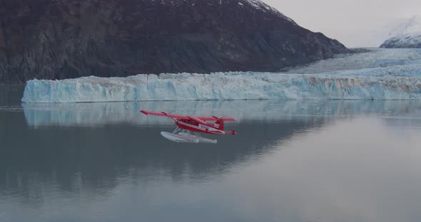 Helicopter aerial shot of low flying biplane over dried river, drone footage