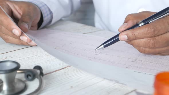 Doctor Hand Analyzing Cardio Diagram Close Up