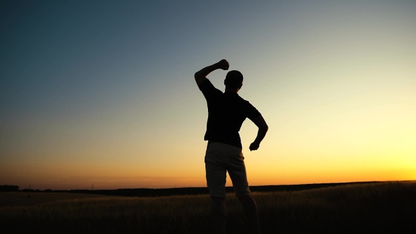 Happy man jumping on sunset sky background. Freedom feel good and travel adventure concept.