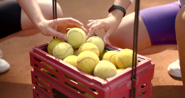 Female Hands Choosing a Ball for Tennis at Court