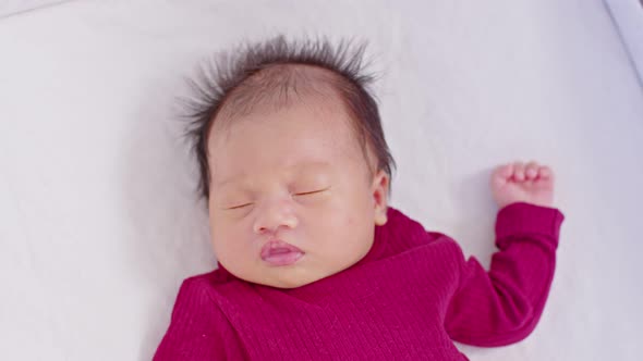 Close up happy newborn baby lying sleeps on a white blanket comfortable and safety