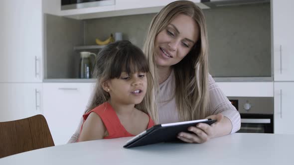 Mom Using Tablet and for Teaching Little Daughter