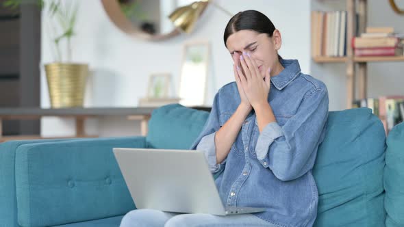 Latin Woman with Laptop Sneezing on Sofa 