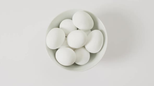 Close up of bowl of white eggs with copy space on white surface