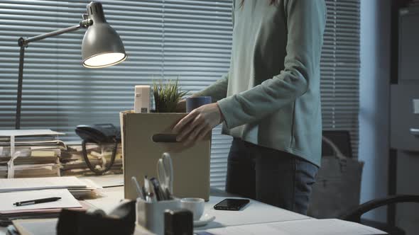 Woman packing her belongings after losing her job