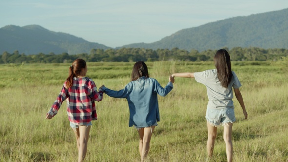 Attractive three young people Asian women holding hands walking having fun together.