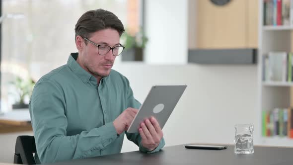 Professional Middle Aged Man Using Tablet at Work