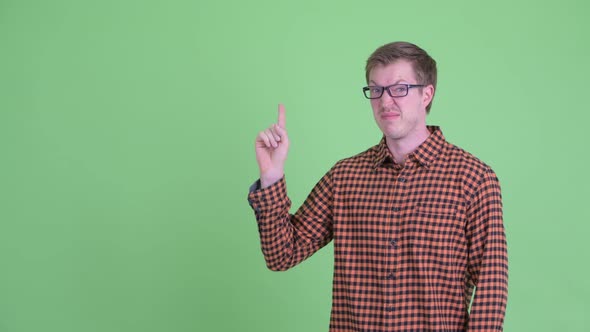 Stressed Young Hipster Man Pointing Up and Giving Thumbs Down