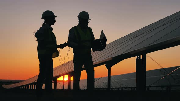 Two Solar Engineers Are Talking About Batteries at Sunset