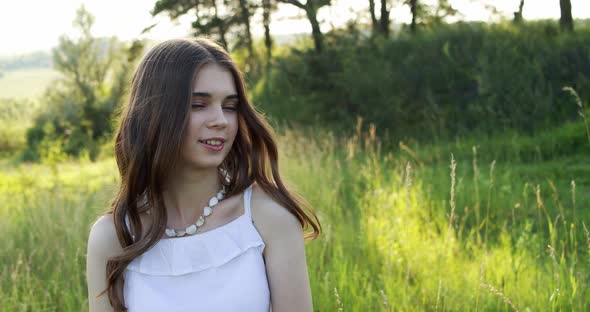 Attractive Smiling European Teen Girl with Natural Makeup Enjoys Moment and Looks Into the Camera in