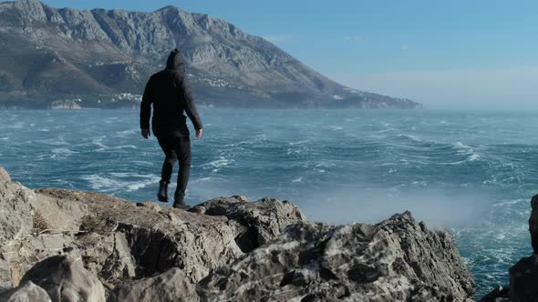 Man in black clothes  Standing near sea In Bad and Storm Weather, Budva, Montenegro