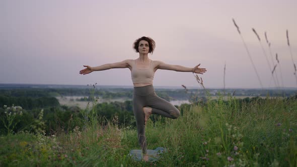 Woman Practises Yoga at Sunrise in Pine Forest