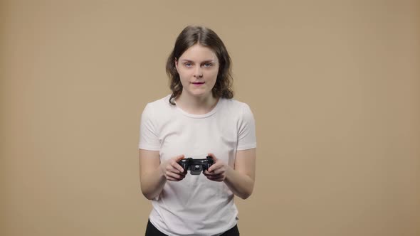 Portrait of Model with Natural Beauty Playing Video Game Using Wireless Controller and Loses