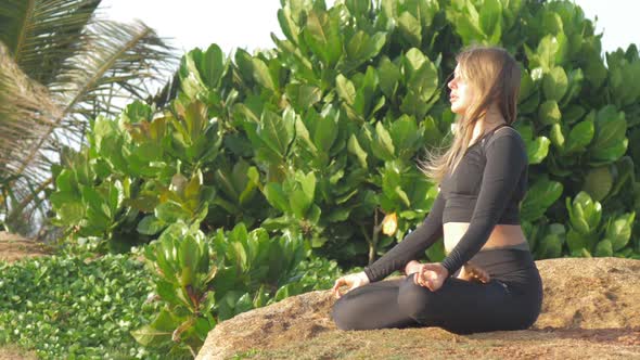 Lady with Long Loose Flowing Hair Meditates in Yoga Pose