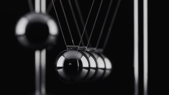 The balls of a Newtons Cradle colliding in slow motion