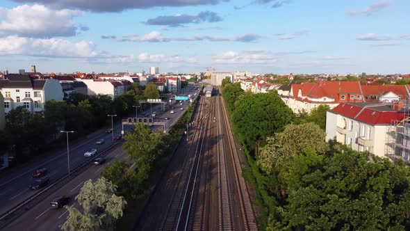 Subway waiting to leave the station next to highway.Gorgeous aerial view flight sinking down drone