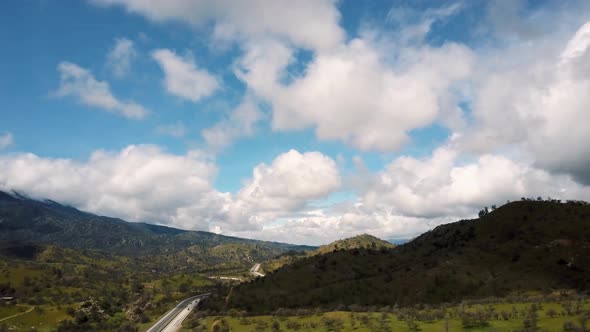 Aerial, Picturesque highway winding through California foothills on cloudy day