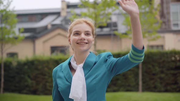 Portrait of Charming Slim Beautiful Woman in Blue Stewardess Uniform Waving Away and Smiling