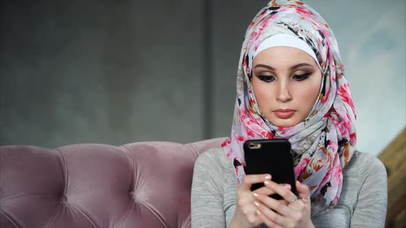 Modern Muslim Woman with Smartphone. Concept of Modern Bright Colorful Hijab