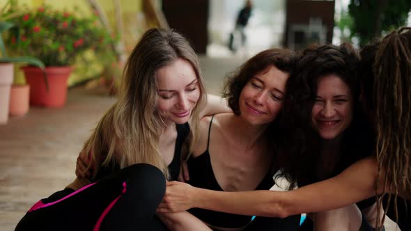 Happy Yoga Group Hugging and Smiling After Workout on the Terrace Close Up