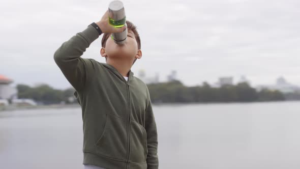 Asian Boy Drinking Water after Outdoor Run