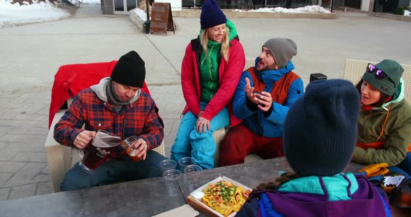 Friends having snacks near campfire