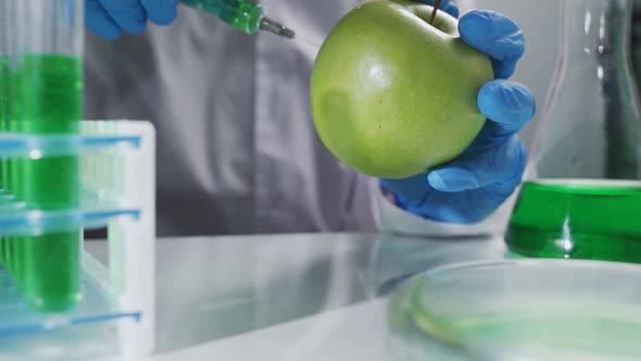 Apple in Genetic Engineering Laboratory with Syringe and Test Tubes Gmo Food Concept