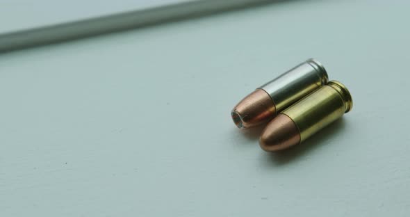 Close Up Pan Right of a Hollow Point and a Round Nose 9mm Bullet Angled Side by Side