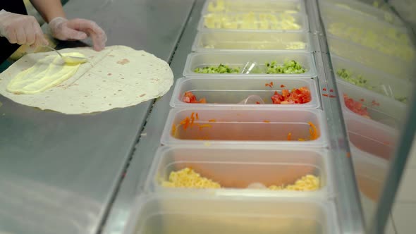 CU Cook Prepares Shawarma or Wok Puts Vegetables on a Flat Cake with Mayonnaise