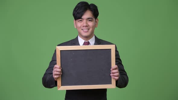 Young Handsome Asian Businessman Showing Blackboard