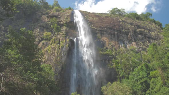 Picturesque Waterfall From High Rocky Cliff with Green Trees