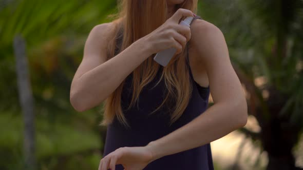 Closeup Shot of a Young Woman Applying an Antimosquito Repellent Spray on Her Skin