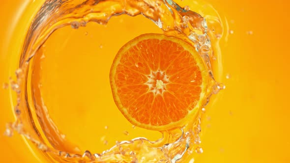 Super Slow Motion Shot of Orange Slice on Orange Gradient Background Splashing To Water at 1000Fps.